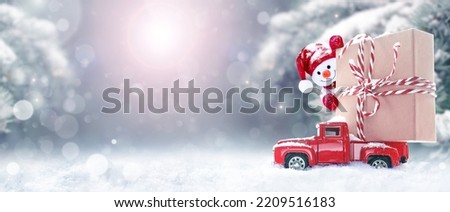Christmas background with snow, snowman and retro red car with gift box. Merry Christmas and happy New Year greeting winter card with copy-space