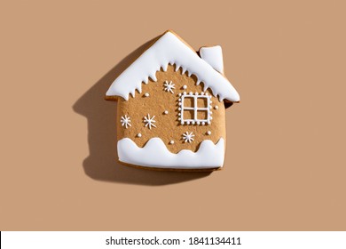 Christmas Bakery. Festive Traditional Cookies. Homemade Culinary. Gingerbread Biscuit Figure House With White Icing Ornament Isolated On Beige Pastel Background.