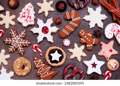 Christmas baking background with assorted cookies and sweet treats. Overhead view on a dark stone background. Holiday baking concept. - Powered by Shutterstock