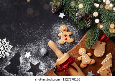 Christmas baking background. Gingerbread cookies, rolling pin and fir tree top view. Homemade sweet pastries for winter holidays.