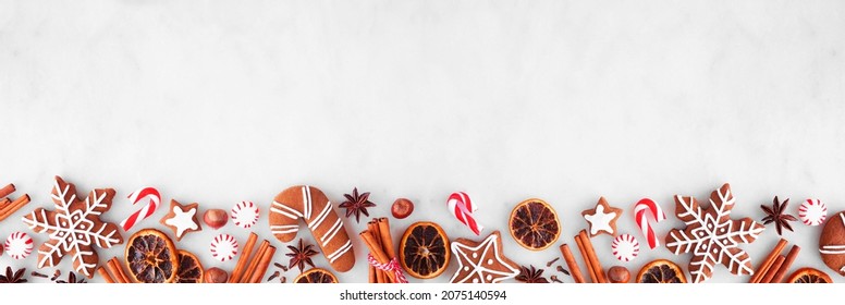 Christmas baking bottom border with cookies, peppermints and spices. Top view over a white marble background with copy space. Holiday baking concept. - Powered by Shutterstock