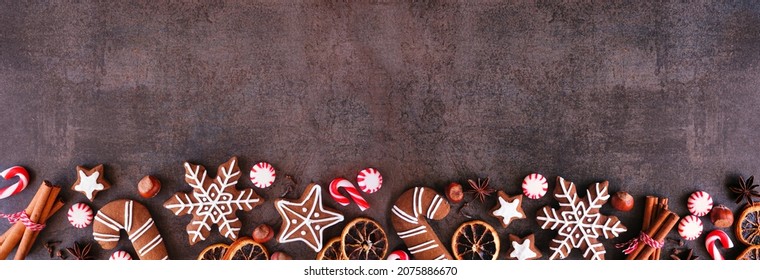 Christmas Baking Bottom Border With Cookies, Peppermints And Spices. Top Down View On A Dark Stone Background With Copy Space. Holiday Baking Concept.