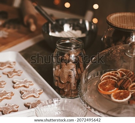 Christmas baking and cooking recipe concept. Food ingredients and preparation process of traditional homemade gingerbread men biscuits in the kitchen at home during winter holidays.