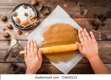 Christmas baking. Ginger dough for gingerbread, gingerbread men, stars, Christmas trees, rolling pin, spices (cinnamon and anise), flour. On the home kitchen wooden table. Copy space top view - Powered by Shutterstock