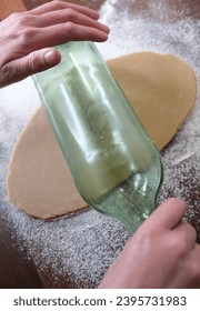 Christmas baking, rolling out dough with a wine bottle as a makeshift