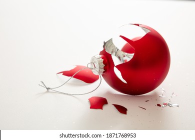 Christmas ball broken isolated on white background, closeup view. Red xmas bauble crashed in pieces. Holiday accident, fragility, anger concept