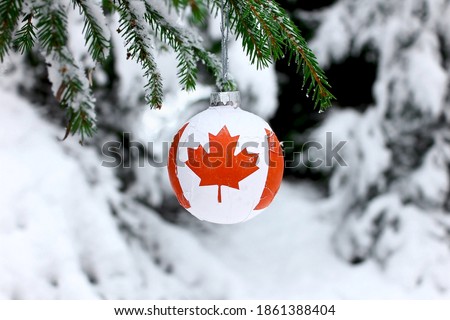 Christmas ball with the Canadian symbol on the flag, decorates the snow tree.