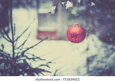 Christmas Ball On A Tree Branch In A Snowy Garden