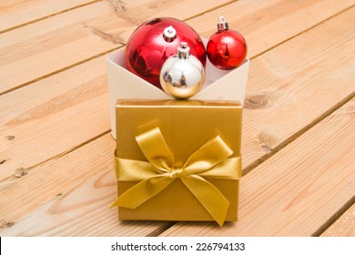 Christmas balls and gift on wood background