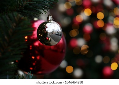 Christmas Balls Hanging On A Fir Branches On Blurred Festive Lights Background. New Year Tree With Decorations On A City Street