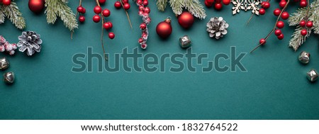 Christmas banner with classic decorations. Fir branches, red balls, jingle bells on turquoise background.