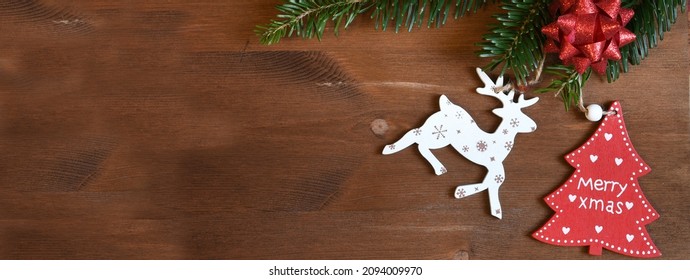 Christmas banner with fir tree branch, pine cones and decorations on wooden background