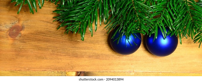 Christmas banner with fir tree branch and christmas spheres on wooden background