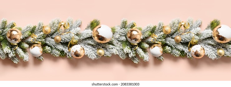 Christmas banner of garland with handmade baubles with gold potal on snowy evergreen fir branches isolated on pastel pink background. Wide size. Peach fuzz trendy color of the year 2024. - Powered by Shutterstock