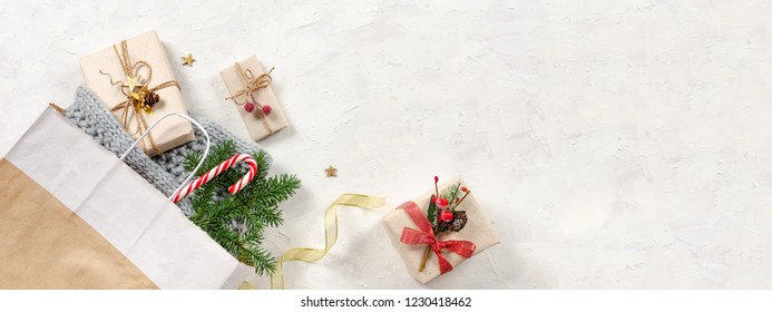 Christmas banner. Winter Holidays sale background. Shopping bag, presents with candy cane, fir branch and golden ribbon. Top view, copy space