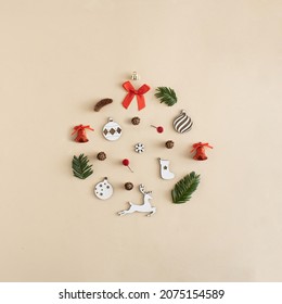 Christmas bauble made of baubles, pinecone, ribbon, snowflakes, red bells, pine branches and reindeer decoration . New Year flat lay.