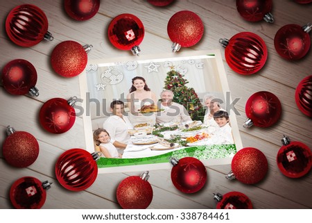 Christmas baubles on table against a happy family christmas card