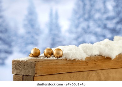 Christmas baubles on wooden board with copy space for products. Blurred background of snowy forest and trees in snowy winter. Snow falling - Powered by Shutterstock