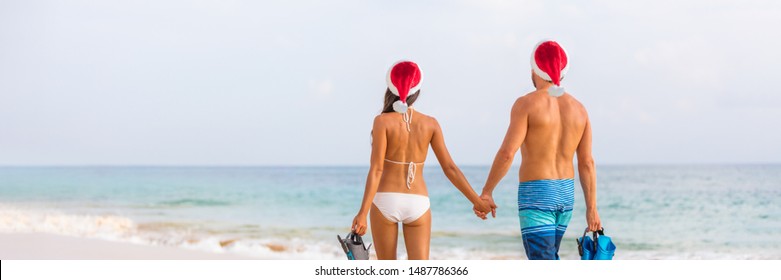 Christmas Beach Couple Caribbean Winter Holiday Couple Wearing Santa Hats On Exotic Vacation. Young People Going Swimming With Snorkel. Snorkeling Activity. Panoramic Banner Landscape.