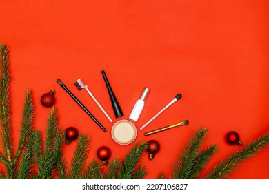 Christmas Beauty Cosmetics Composition With Brushes Tools And Accessories With New Year Fir Spruce Branches Decorations On Red Background. Stylish Concept. Flat Lay, Mock Up Top View With Copy Space.