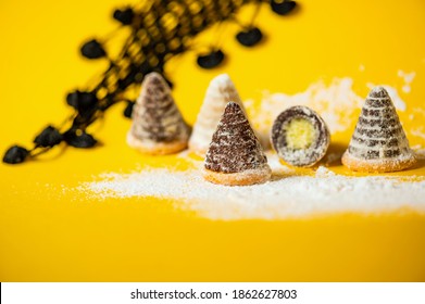 Christmas beehive cake on snowy yellow background with black lace scarf, closeup, copy space.