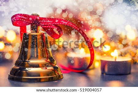 Christmas bell with red ribbon candles and snowy background. Happy christmas text on red ribbon.