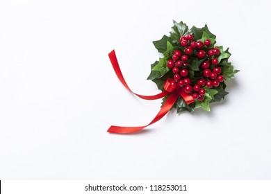 Christmas Berries Garland With Red Ribbon And Green Leaves Over White Background.