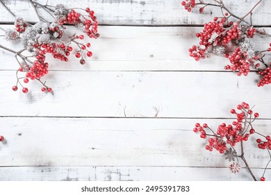 Christmas berry garland and pine cone border on an old white wood background - Powered by Shutterstock