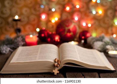 Christmas And Bible With Blurred Candles Light Background