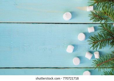 Christmas border with branch of fir tree and marshmallows on wooden background. Top view copy space - Shutterstock ID 770721718