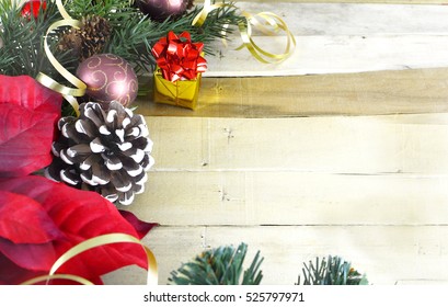 Christmas border of evergreen, pinecones, ribbons, balls and a poinsettia on a wooden background. Copy space. - Powered by Shutterstock