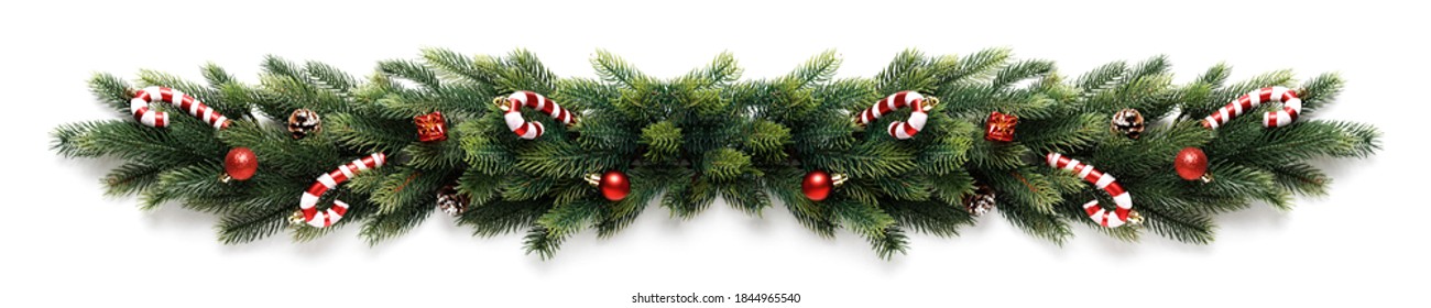 Christmas border frame of tree branches with red balls, pine cones and candies