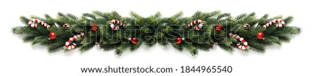 Christmas border frame of tree branches with red balls, pine cones and candies