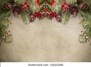 A Christmas border at top of frame consisting of artificial pine tree fronds and decorative ornaments, framing top and sides of grungy parchment. - Powered by Shutterstock