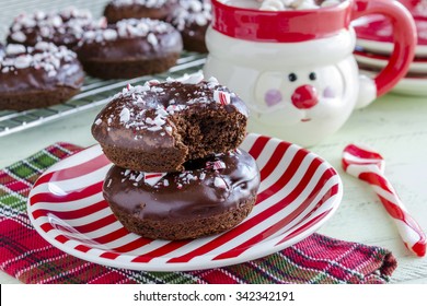 Christmas breakfast table with double chocolate peppermint donuts sitting on red and white striped plate with hot cocoa in Santa mug - Powered by Shutterstock