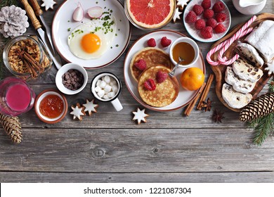 Christmas brunch or breakfast table. Festive brunch set, meal variety with fried egg, appetizers platter, croissant, granola, smoothy and traditional sweets . Overhead view