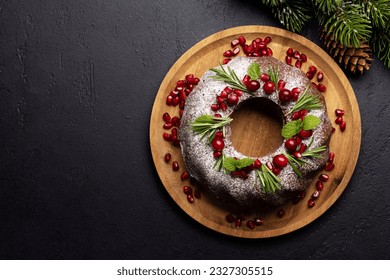 Christmas cake decorated with pomegranate seeds, cranberries and rosemary. Flat lay with copy space - Powered by Shutterstock