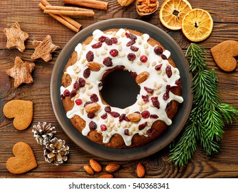 Christmas cake with fruits and nuts on wooden table, top view
