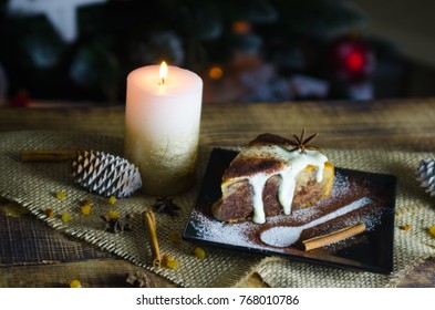 Christmas cake with white cream on wooden table with Christmas tree in background and candle - Shutterstock ID 768010786