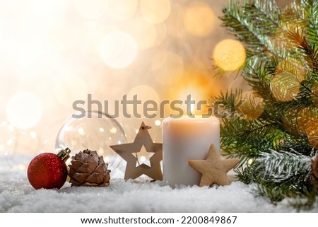 Christmas candle on snow-covered boards - decoration with natural elements, twigs, pine cones, Christmas decorations. Copy space.