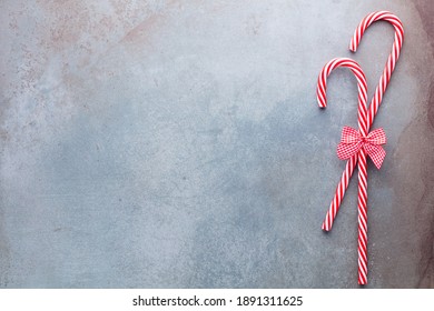 Christmas candy cane lied evenly in row on blue background. Flat lay and top view