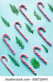 Christmas Candy Cane Lied Evenly In Row On Blue Background. Flat Lay And Top View