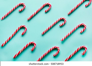 Christmas Candy Cane Lied Evenly In Row On Blue Background. Flat Lay And Top View