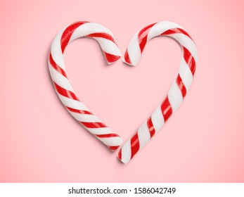 Christmas Candy Canes Shaped Like Heart On Pink Background