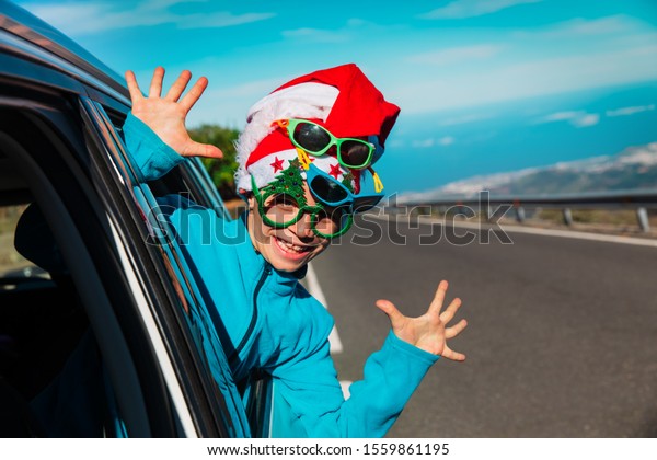 christmas car travel- happy child travel on road\
in winter