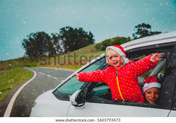 christmas\
car travel- happy girl and boy travel in\
winter