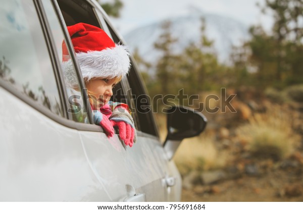 christmas car travel- happy little girl loves\
travel in winter