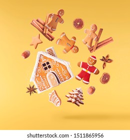 Christmas Card Conception. Christmas Gingerbread Man And Cookies Falling In The Air On Yellow Background. Levitation Concept.High Resolution Image