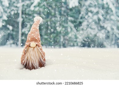 Christmas card with cute gnome in snowy winter forest, copy space. Fairytale snowfall