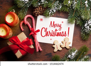 Christmas card with gingerbread cookies and fir tree branch covered by snow on stone background. Top view - Shutterstock ID 1514462474